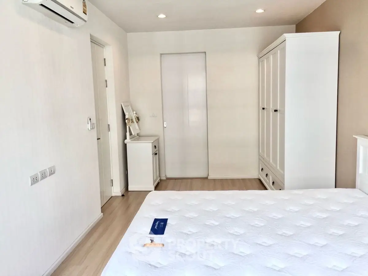 Bright and airy bedroom with modern white furniture and air conditioning