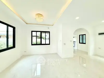 Spacious modern living room with elegant chandelier and large windows