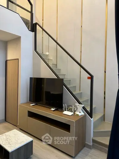 Modern duplex living room with sleek staircase and stylish TV console