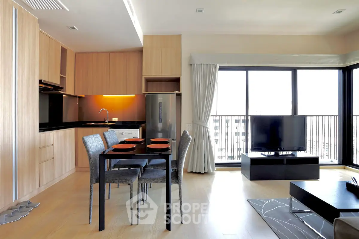 Modern open-plan living room with kitchen, dining area, and balcony view in a stylish apartment.