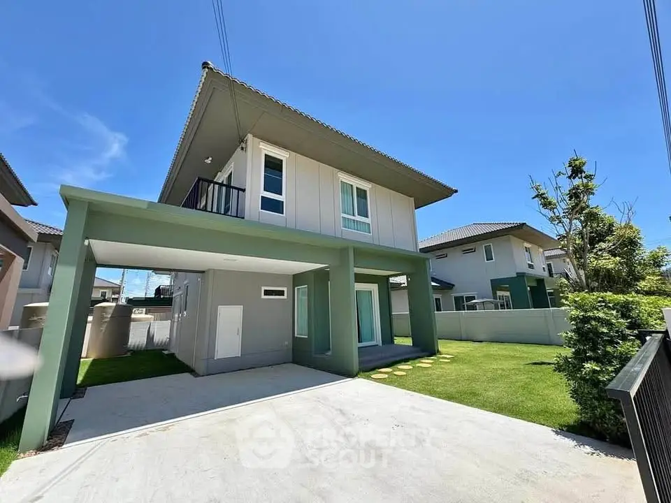 Modern two-story house with spacious driveway and lush green lawn under clear blue sky.