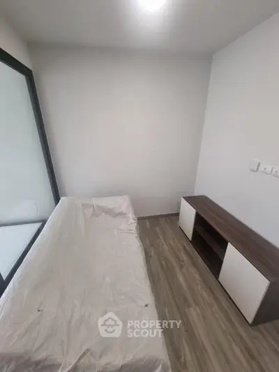 Minimalist bedroom with single bed and modern storage unit, perfect for compact living spaces.
