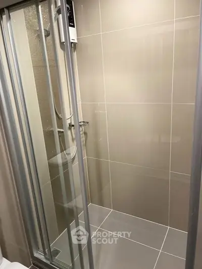 Modern bathroom with sleek glass shower enclosure and tiled walls