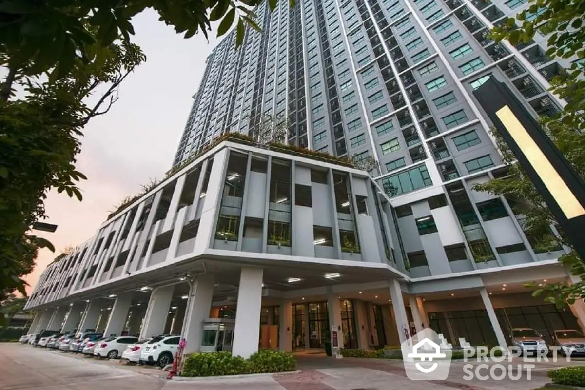 Modern high-rise condominium with lush greenery and spacious parking area