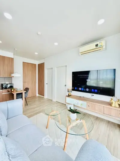 Modern living room with sleek furniture and large TV, perfect for relaxation.