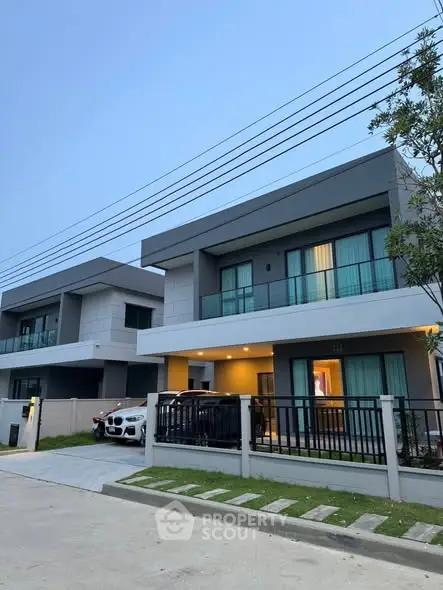 Modern two-story houses with balconies and carports in a suburban neighborhood.
