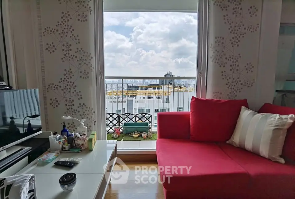 Chic living room with red sofa and balcony view of city skyline