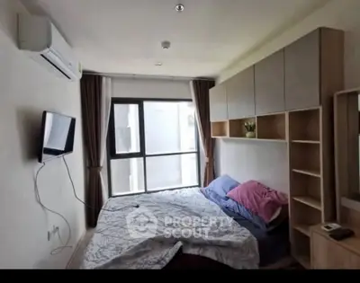 Cozy bedroom with modern furnishings and large window for natural light.