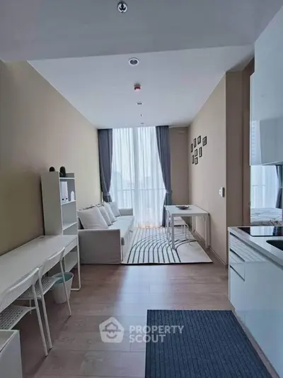 Modern living room with sleek design and natural light, featuring cozy seating and stylish decor.