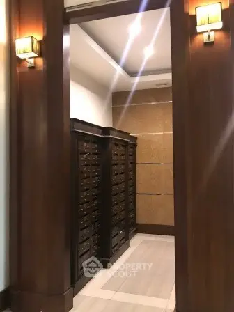 Elegant apartment building mailroom with wooden paneling and modern lighting.