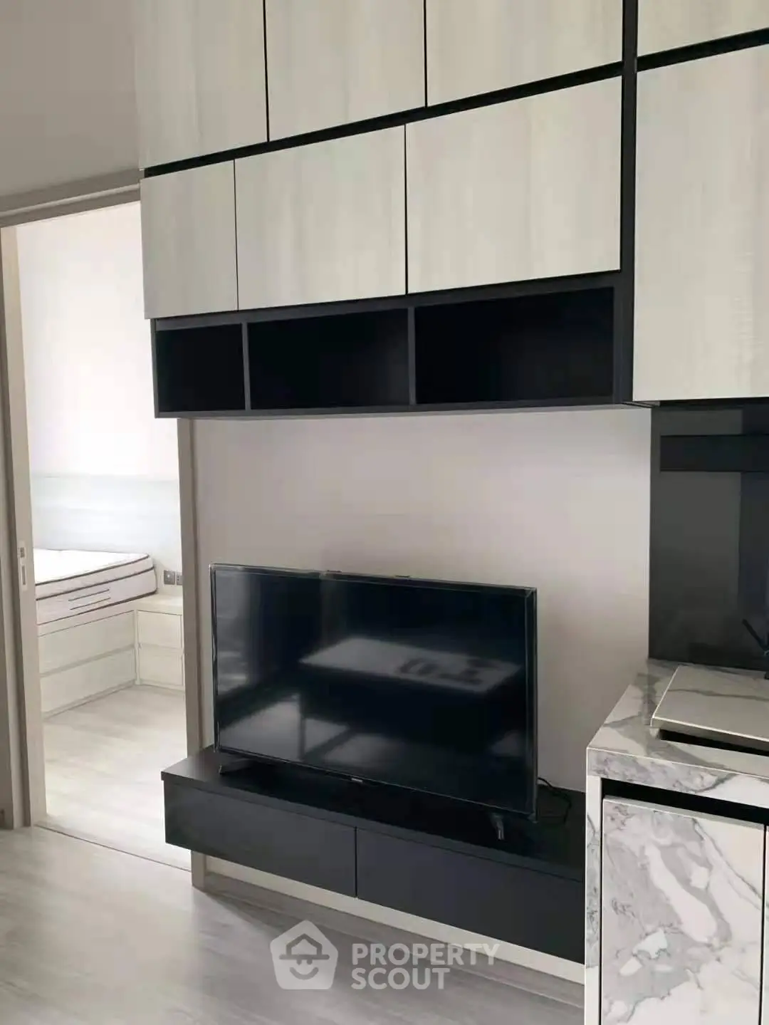 Modern living room with sleek cabinetry and mounted TV in stylish apartment.