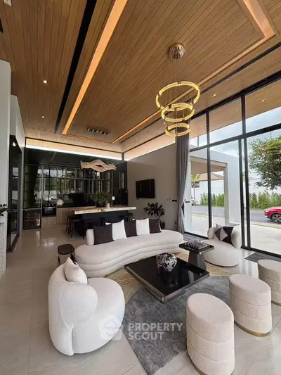 Luxurious modern living room with elegant furniture and open kitchen, featuring high ceilings and large windows.