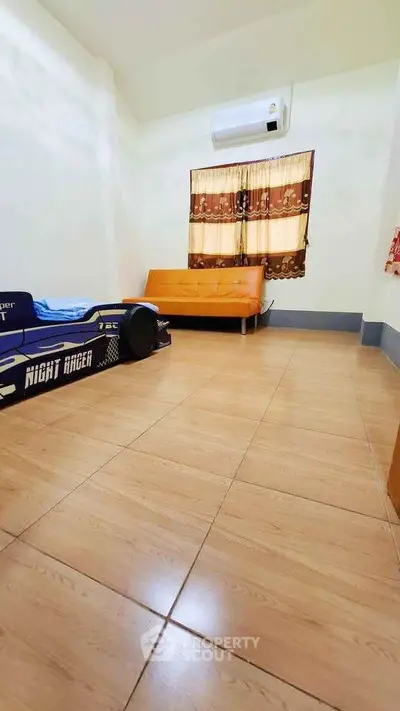 Spacious bedroom with unique race car bed and modern sofa