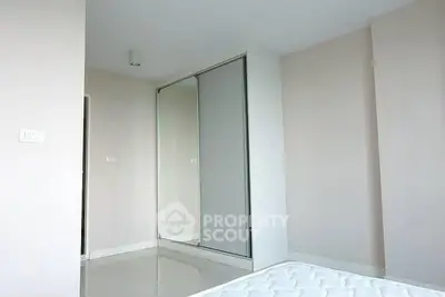 Minimalist bedroom with mirrored wardrobe and white walls