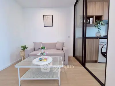 Modern living room with cozy sofa and sleek kitchen area, perfect for urban living.