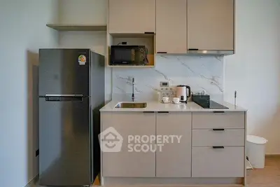 Modern kitchen with sleek cabinetry and stainless steel appliances in a stylish apartment.