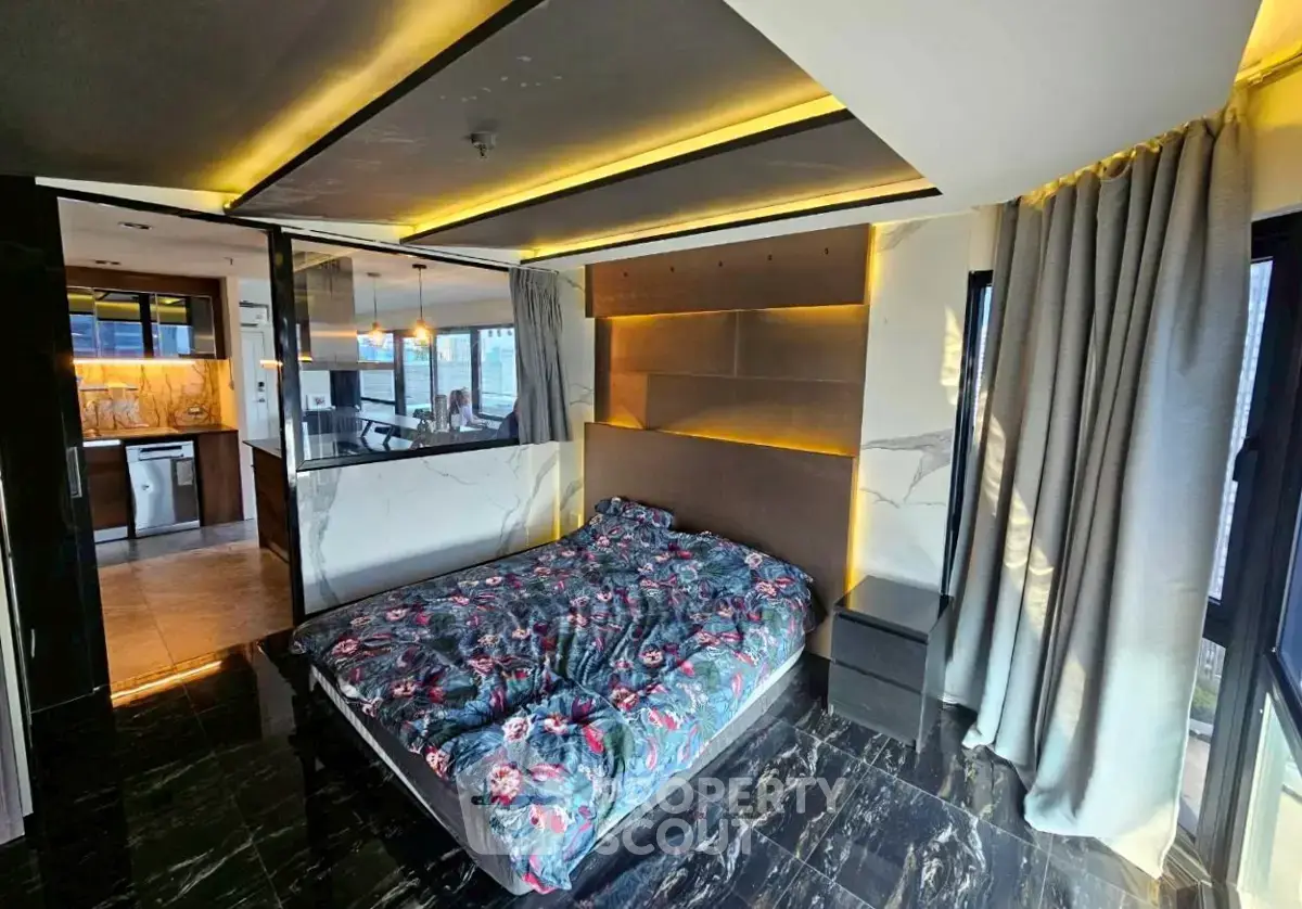 Luxurious modern bedroom with stylish lighting and open kitchen view