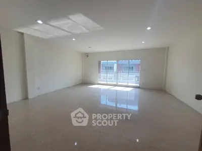 Spacious empty living room with large windows and bright natural light