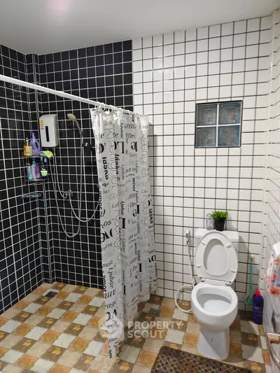Modern bathroom with stylish black and white tiles and shower curtain