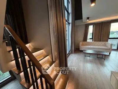 Modern living room with stylish staircase and large windows