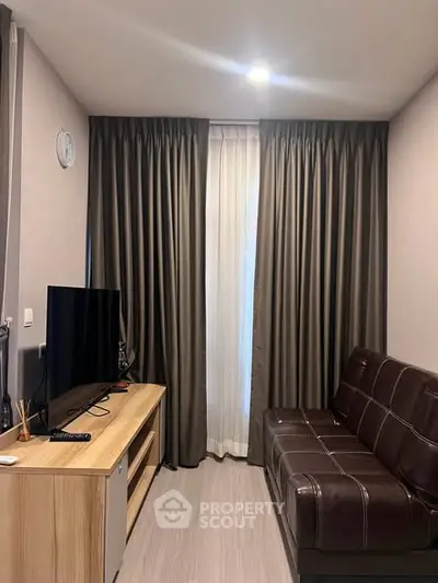 Cozy living room with modern decor, featuring a sleek TV setup and stylish curtains.