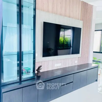 Modern living room with sleek TV unit and glass cabinet