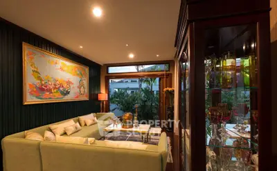 Luxurious living room with elegant decor and large windows offering garden views.