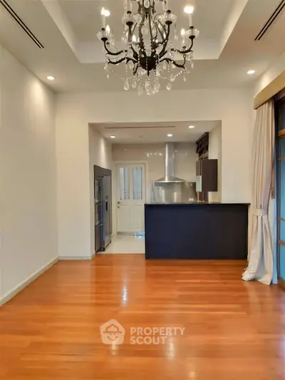 Elegant open layout kitchen with chandelier and hardwood floors in modern home