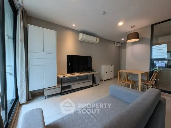Modern living room with sleek furniture and large window for natural light.