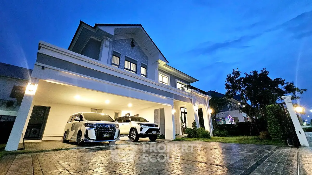 Luxurious modern house with spacious driveway and elegant exterior lighting at dusk.