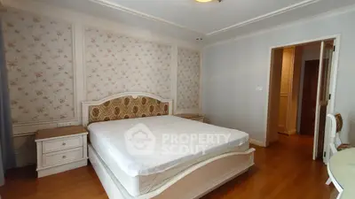 Spacious bedroom with elegant floral wallpaper and classic wooden furniture