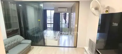 Modern apartment interior with spacious living room and bedroom, featuring sleek furniture and large windows.
