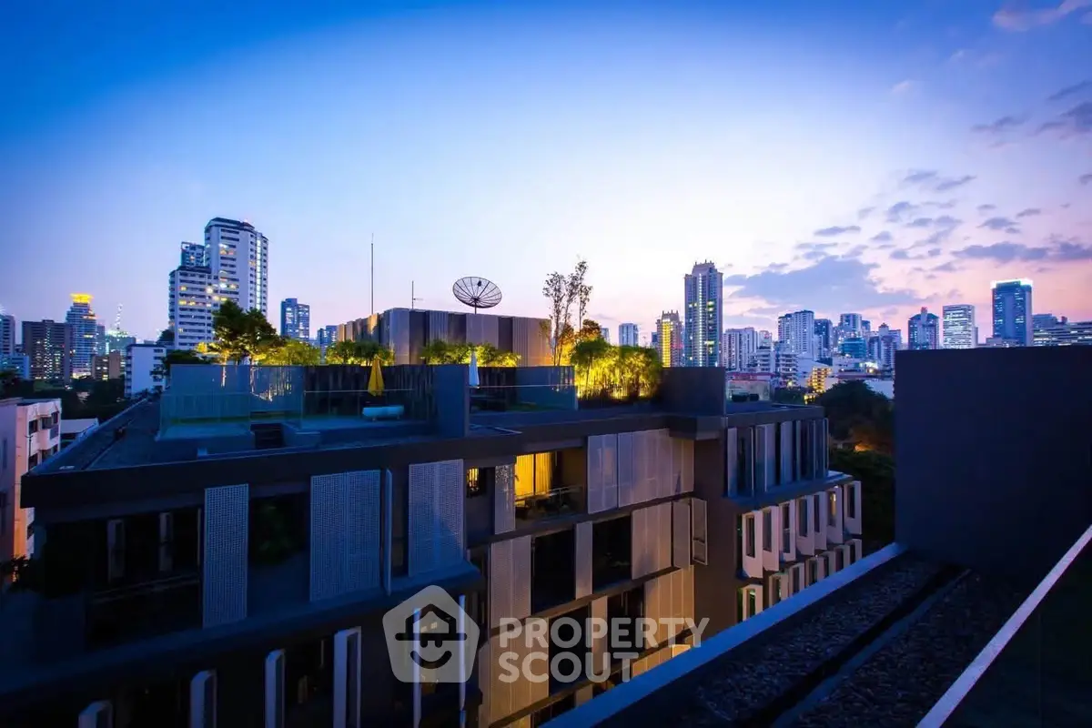 Stunning rooftop view of modern cityscape at dusk with lush greenery and skyline.