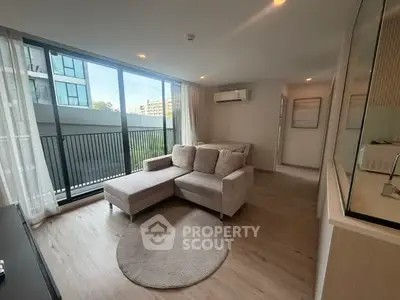 Modern living room with large windows and stylish furniture in a contemporary apartment.