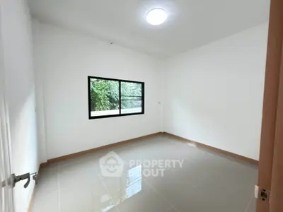 Spacious empty room with large window and glossy tiled floor, perfect for customization.