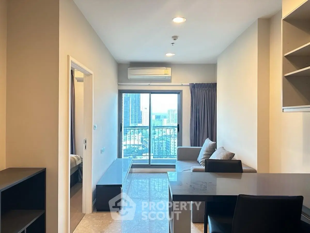 Modern living room with city view, featuring sleek furniture and ample natural light.