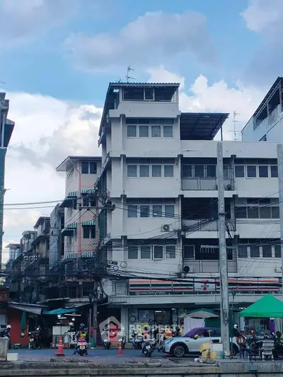 Urban street view with multi-story building and bustling market scene
