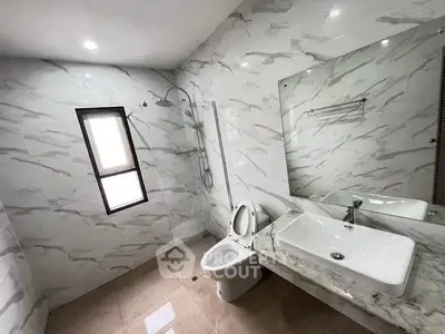 Spacious modern bathroom with elegant marble tiles and large mirror