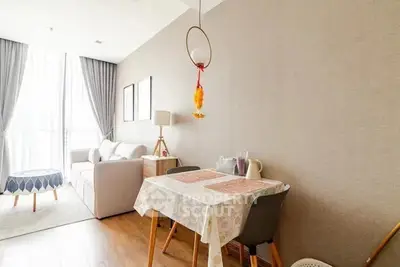 Cozy living room with dining area, modern decor, and natural light.