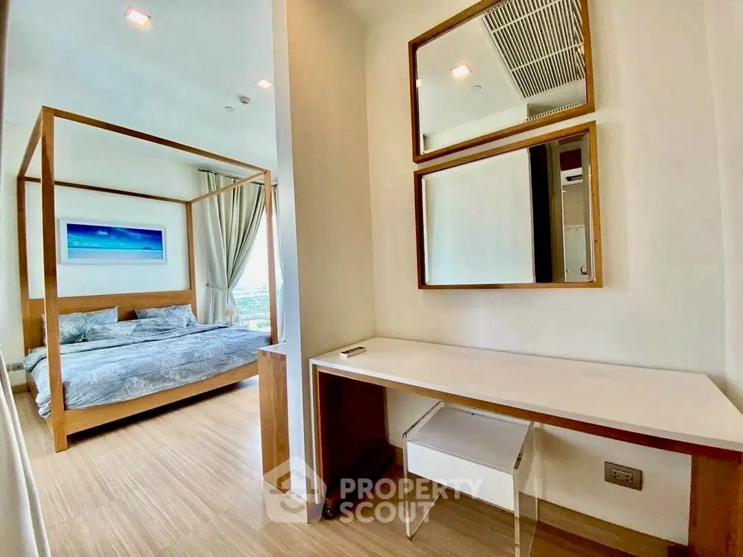 Modern bedroom with stylish decor and wooden flooring, featuring a cozy bed and elegant mirrors.
