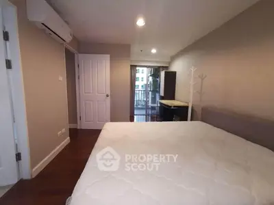 Spacious bedroom with balcony access in modern apartment