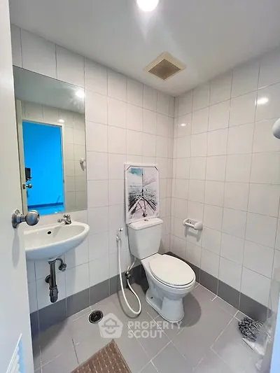 Modern bathroom with sleek white tiles and contemporary fixtures in a stylish real estate property.