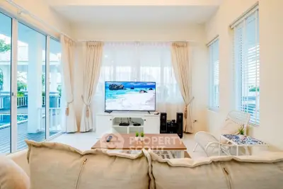 Bright and airy living room with large windows and modern decor, perfect for relaxation.