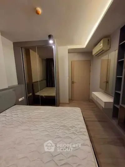 Modern bedroom with mirrored wardrobe and air conditioning in a stylish apartment.