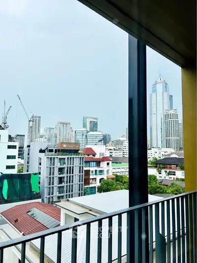 Stunning cityscape view from a modern balcony, showcasing urban skyline and high-rise buildings.