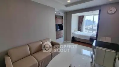 Modern open-plan living room with cozy sofa and bright bedroom view