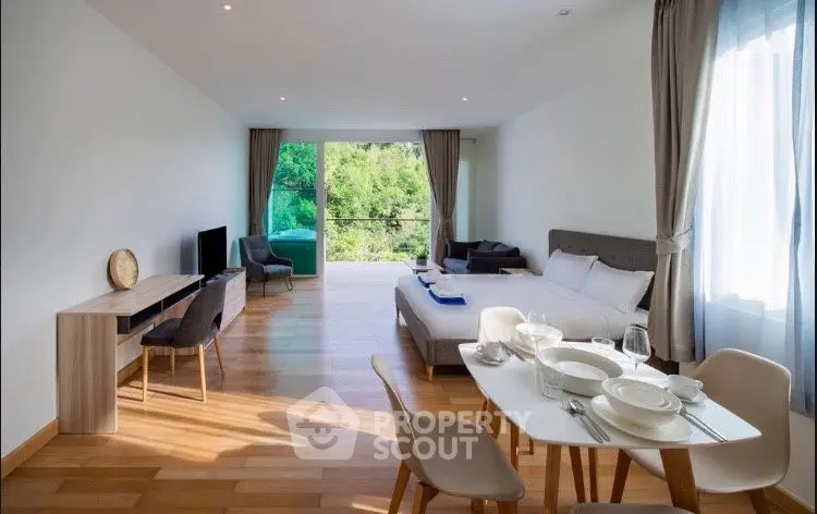 Spacious open-plan living room with modern decor and scenic balcony view.