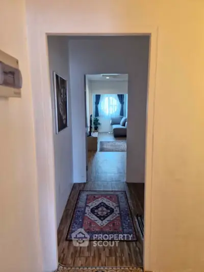 Inviting hallway leading to a cozy living room with natural light and elegant decor.