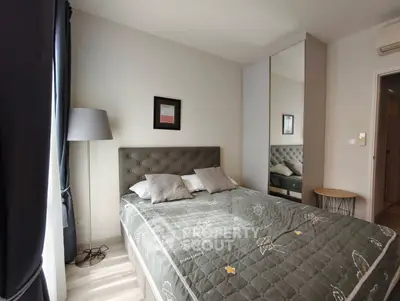 Cozy bedroom with modern decor and mirrored wardrobe in a stylish apartment.
