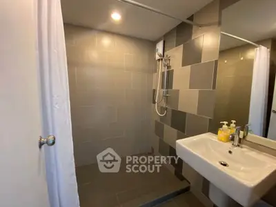 Modern bathroom with sleek tiles and a spacious shower area